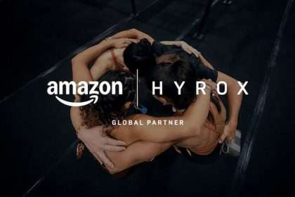 Vista aérea de atletas de HYROX abrazándose con logo de Amazon y HYROX sobre ellos