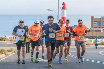Corredores participantes de la Media Maratón Valparaíso con el Faro Punta Ángeles detrás de ellos