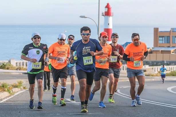Corredores participantes de la Media Maratón Valparaíso con el Faro Punta Ángeles detrás de ellos