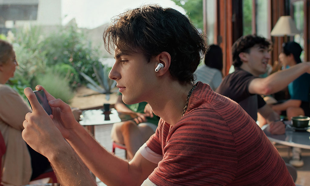 Muchacho jugando un videojuego en su celular con los HUAWEI FreeBuds Neo