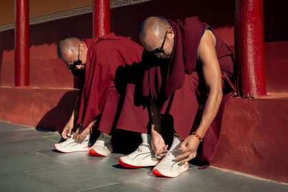 Monjes budistas poniéndose zapatillas PUMA en el Maratón de Ladakh