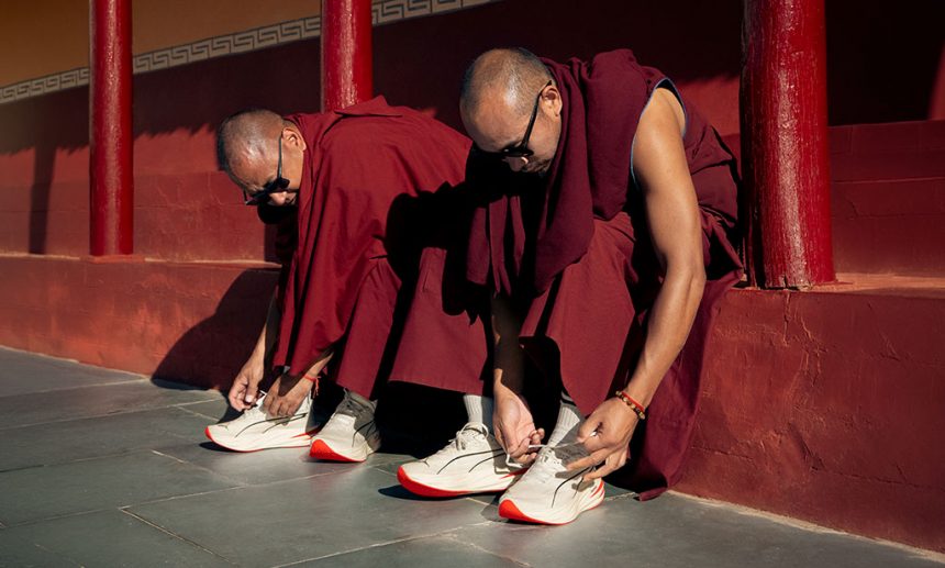 Monjes budistas poniéndose zapatillas PUMA en el Maratón de Ladakh