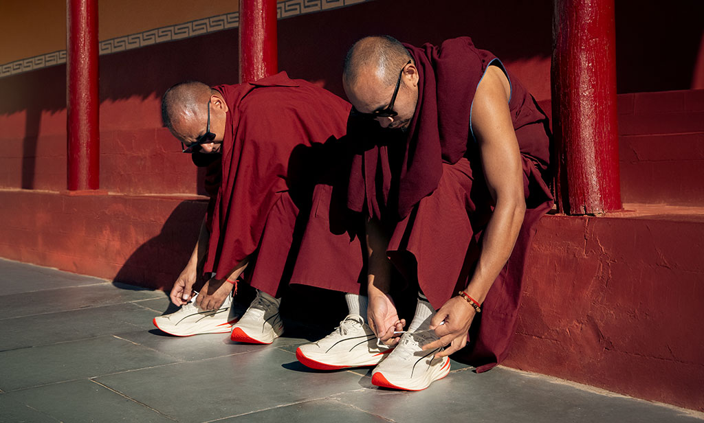 Monjes budistas poniéndose zapatillas PUMA en el Maratón de Ladakh