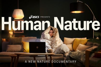 Portada de ASICS Human Nature que muestra una mujer sentada en un sofá tapada con un cobertor y viendo TV en un laptop
