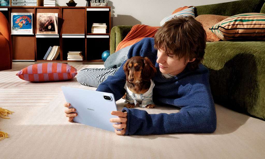 Joven jugando videojuegos en su HUAWEI MatePad Air acompañado de tu perro